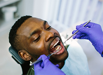 A man having his teeth examined at the dental office.