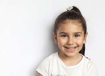 Child smiling in front of white background 
